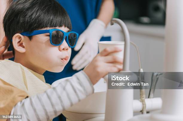 Asian Chinese Dental Young Patient Washing Out His Mouth Stock Photo - Download Image Now