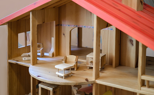 Close-up of a wooden dollhouse with doll furniture and accessories for the doll house.