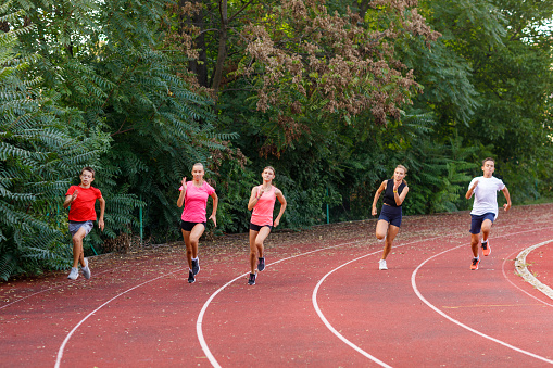 Diverse group of teenage runners on an outdoor track.