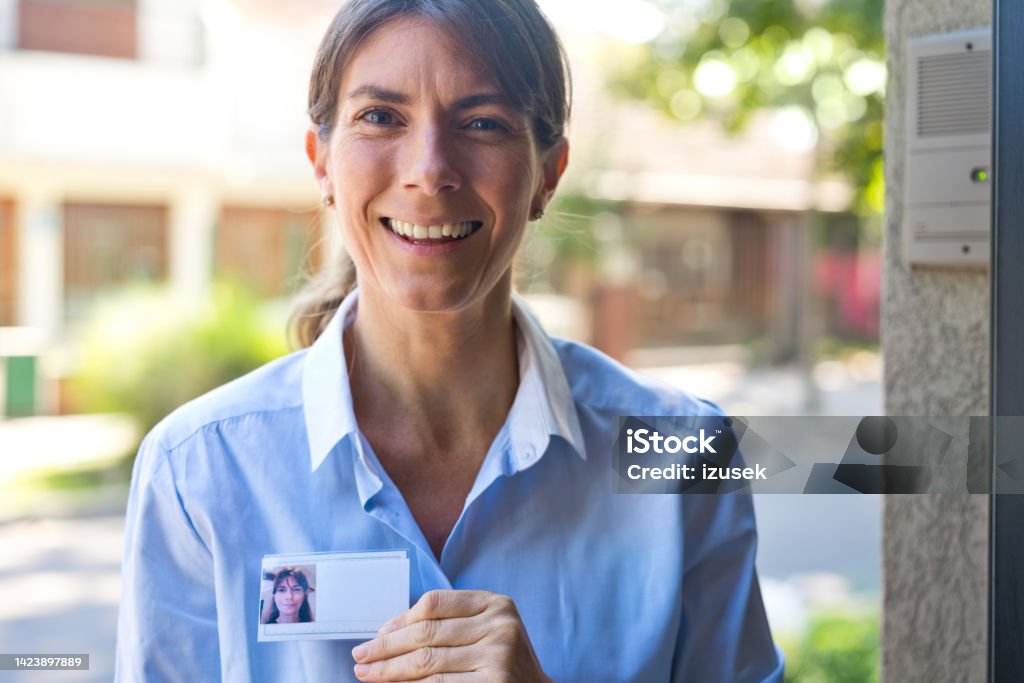 Portrait of female caregiver Pleased nurse standing outdoor and smiling at camera. Adult Stock Photo