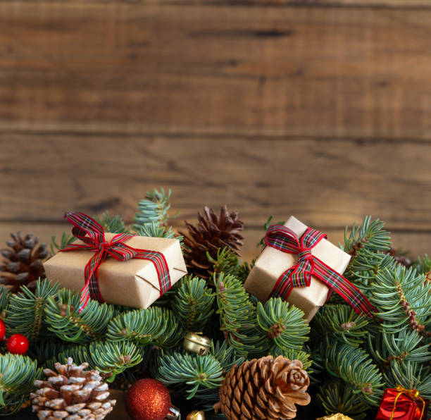 istock Wrapped gift boxes on reen fir branches near Christmas decorations and pine cones 1423897898