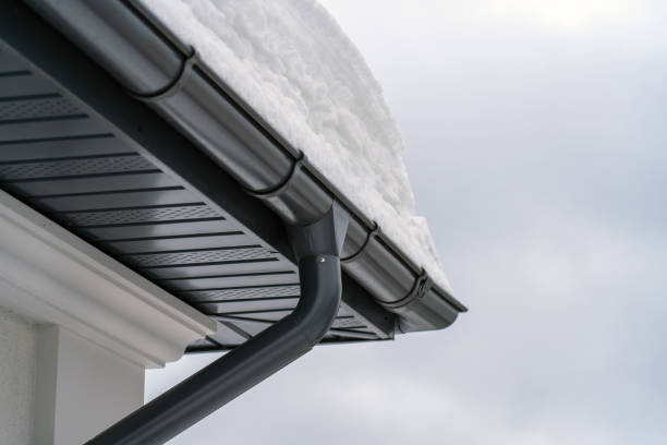 istock Metal Downpipe system, Guttering System, External downpipes and drainage pipes under snow. Corner of house with roof made of gray metal tiles and gutter covered with thick layer of snow in winter. 1423898449