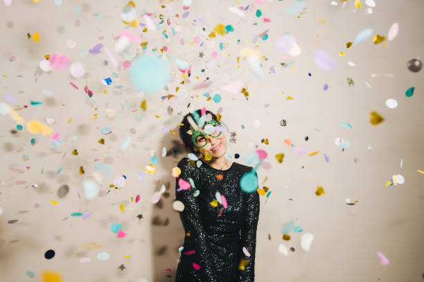 Portrait of cute woman blowing confetti