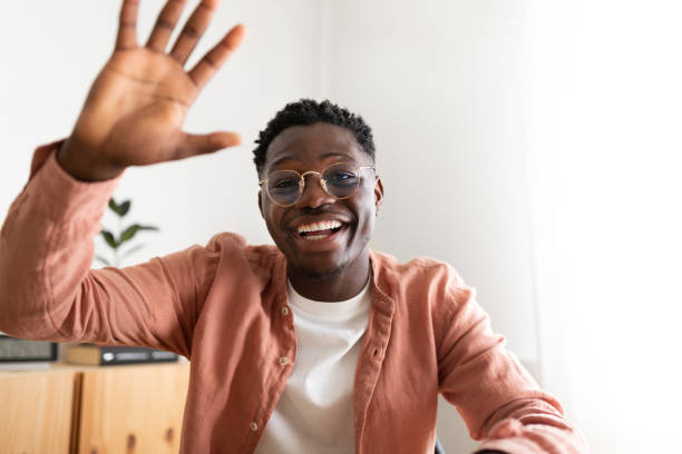 istock African american young man looking at camera waving hand saying hello during video call. 1423903625