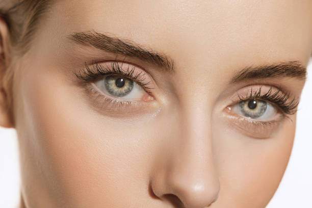 ojos azules y formas perfectas de cejas. retrato de cerca de una hermosa joven mirando a la cámara. concepto de cosmética, maquillaje, tratamiento ecológico, cuidado de la piel. - bella fotografías e imágenes de stock