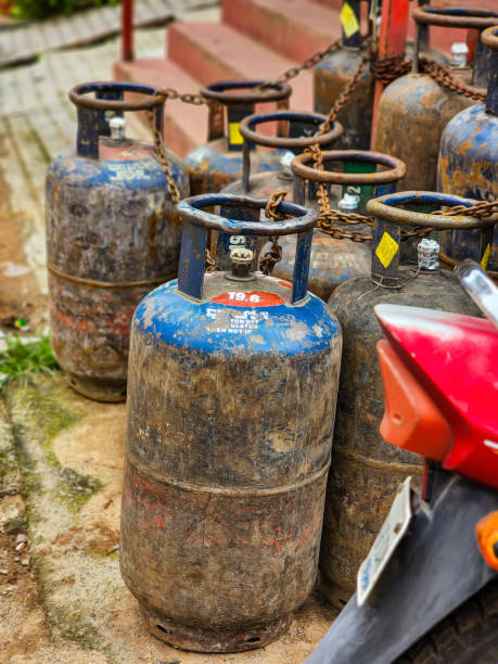 Bunch of old rusty LPG gas cylinders for kitchen cooking kept outside of the gas station or store for filling gas. Picture captured under natural light. focus on object stock photo