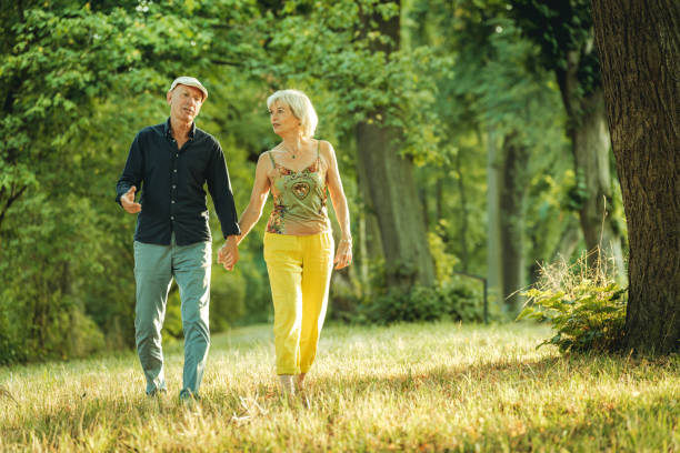 istock happy senior couple holding hand walking through a park 1423930526