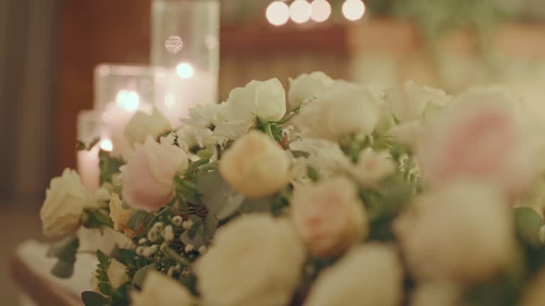 Luxury wedding, party or birthday table decor with candle light and bokeh. Flowers, rose scent and glass candles at banquet or event hall. Pastel roses, night glow and hospitality, a rich celebration