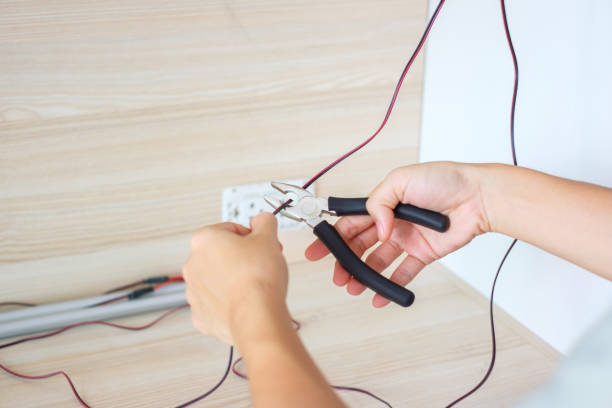 istock Electrician cuts electrical wires with pliers, Wiring cables installation for socket plug. Fixing, Renovation, Repair, service and development of home and apartment concepts 1423931547