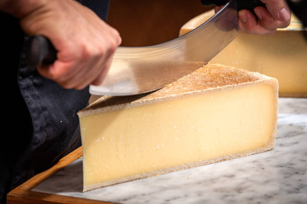 有名で味付けされたチーズのハベれた部分はワイヤーで切られました - swiss cheese ストックフォトと画像