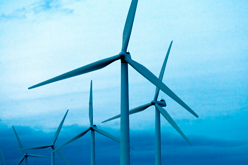 Aerial view of wind mill farm , green hills along the sea.