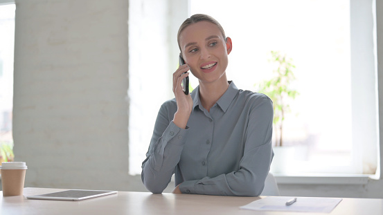 Young Woman Talking on Phone in Office