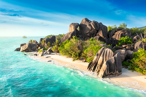 Beautifully shaped granite boulders reflecting in the water at Anse Source d'Argent beach, La Digue island, Seychelles