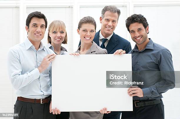 Businesspeople Holding A Blank Poster And Smiling Stock Photo - Download Image Now - 20-29 Years, 30-39 Years, Adult