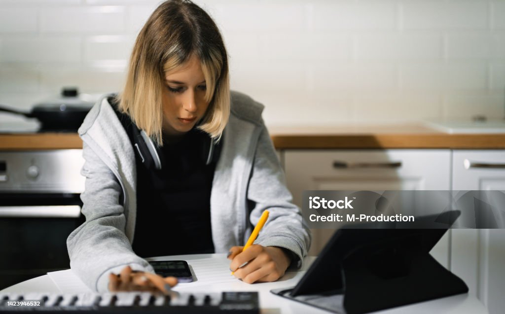 Teenage girl writing composing music at home. Midi-Pyrénées Stock Photo