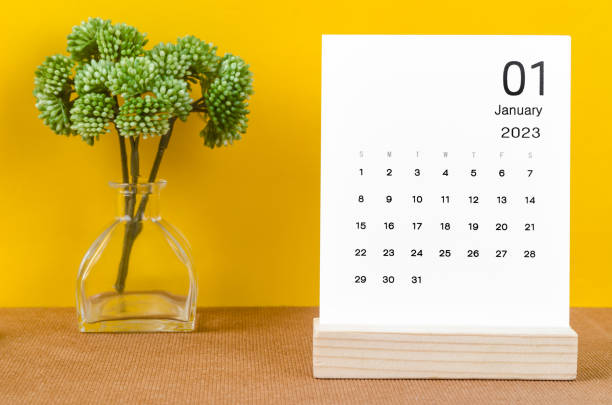 el calendario mensual de escritorio de enero de 2023 para el año 2023 sobre fondo amarillo. - enero fotografías e imágenes de stock