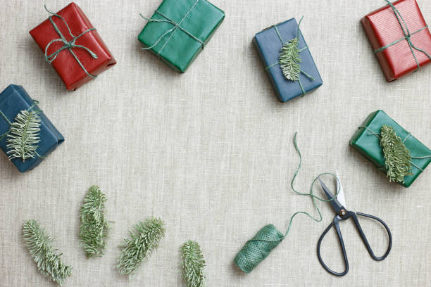 istock Christmas and New Year gift boxes, zero waste, eco friendly packaged gifts in kraft colored paper, green fir tree branches on table, preparation colorful xmas presents, eco christmas concept 1423947225