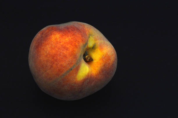 istock Closeup of a peach on the black background 1423949717