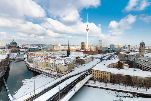 high angle view over Berlin cityscape on snow capped river and Cathedral and TV-tower in the background on winter day