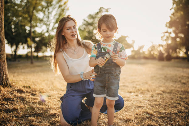 istock Mother And Daughter Having Fun While Blowing Bubbles Together Outdoors 1423950944