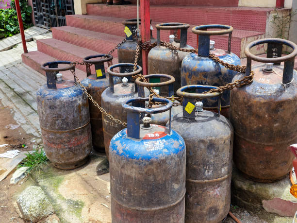 Hyderabad,India- August 6th 2022; Bunch of old rusty LPG gas cylinders for kitchen cooking kept outside of the gas station or store for filling gas.Picture captured under natural light. focus on object stock photo