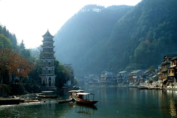 cidade antiga de fenghuang há 20 anos: pagode, barcos turísticos e habitações tradicionais ao longo do rio - fog old stone bridge - fotografias e filmes do acervo