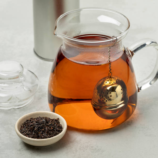 Glass teapot with a metal tea infuser and Ostfriesen tea in front