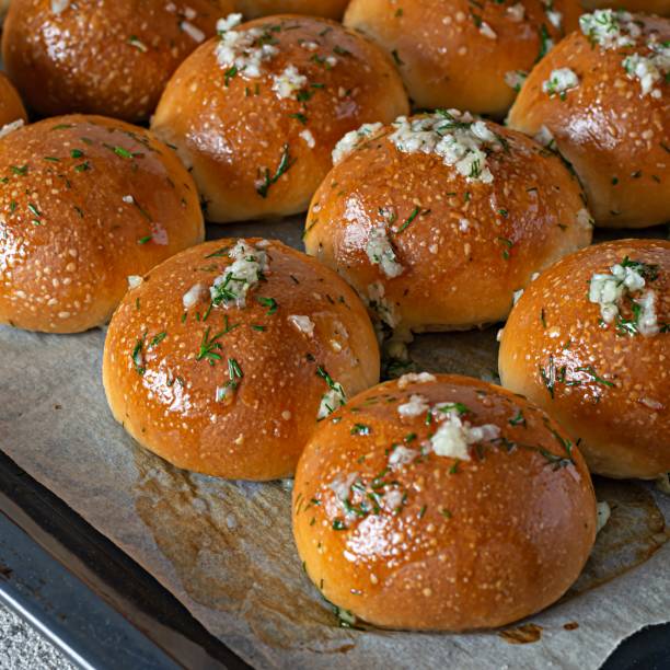 istock Freshly baked buns (pampushki) with garlic and dill for the first course (soup) on a baking tray. National Ukrainian dish, food. Selective focus. 1423958467