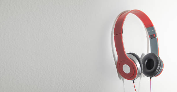 istock Red headphones on the wall. Music. Technology 1423960913