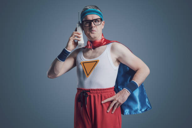istock Funny superhero making a phone call using a cordless telephone 1423961201