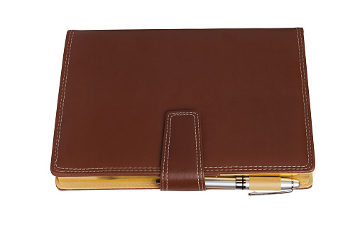 Leather notebook and pencil on white background.