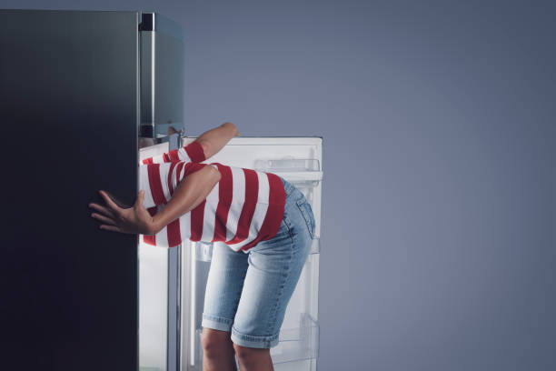 istock Woman with her head in the fridge 1423970424