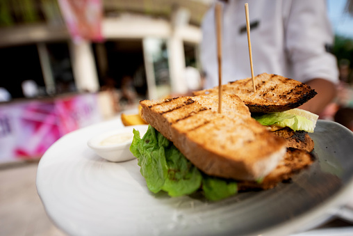 Serving fresh toast sandwiches on a plate in outdoor restaurant