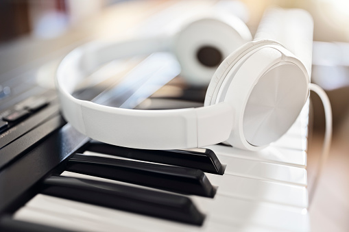 Headphones on piano keyboard concept for music tuition, lessons, education or recording