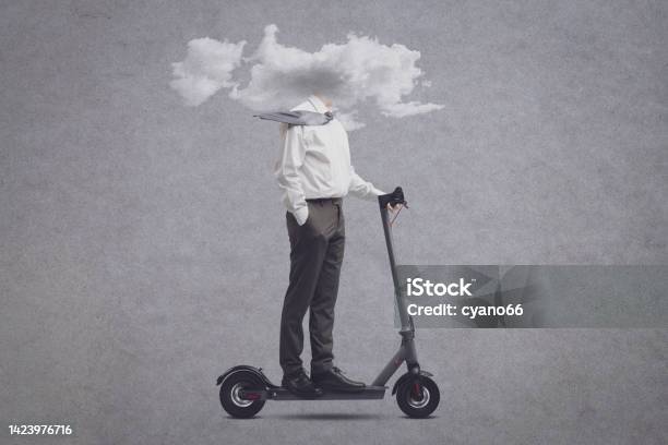 Businessman With Head In A Cloud Riding An Electric Scooter Stock Photo - Download Image Now