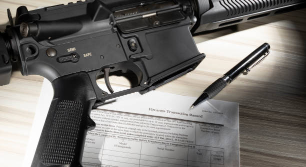 istock Rifle and background check form with pen 1423976906