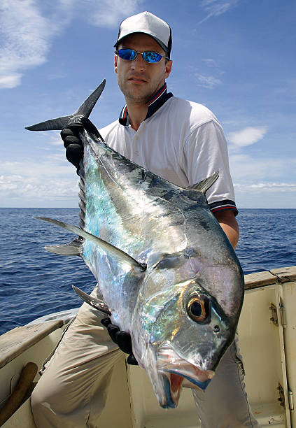 istock A man holding a Trevally Jack fish in a boat 142397983