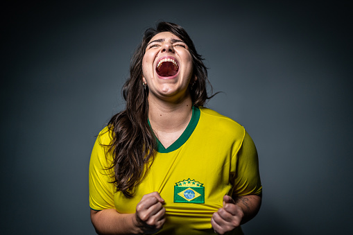 Brazilian young fan celebrating on yellow uniform