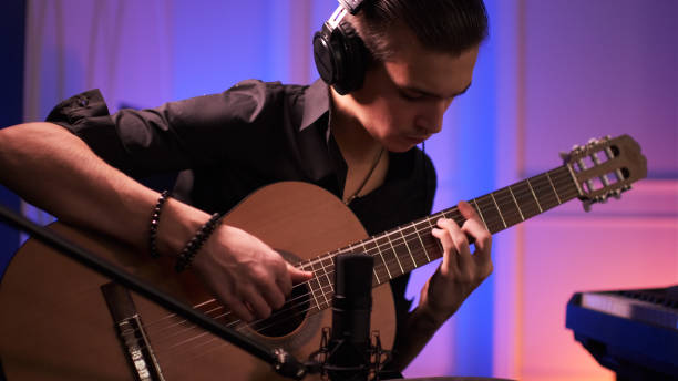 istock Musician in a headphones records his composition in a music Studio using professional audio microphone. 1423980632