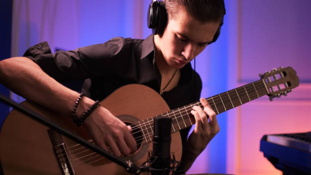 istock Musician in a headphones records his composition in a music Studio using professional audio microphone. 1423980642