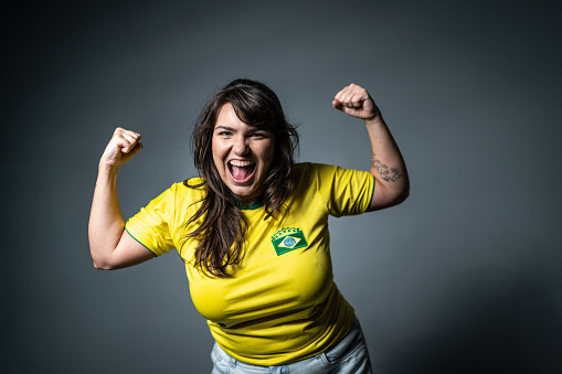 Brazilian young fan celebrating on yellow uniform