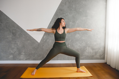 Brazilian woman practicing yoga at her home