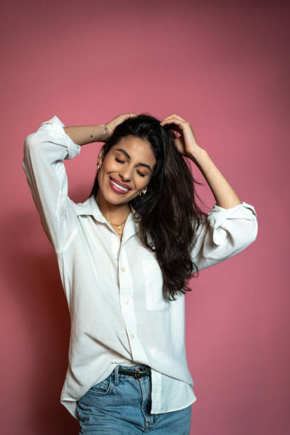 istock Young woman smiling on a pink background 1423982248