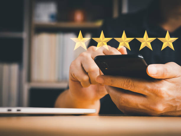 istock Man's hand holding mobile phone to rating score. 1423982620