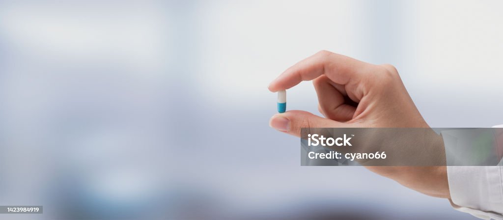 Professional doctor holding a pill Professional doctor holding a pill, medicine and treatment concept Antibiotic Stock Photo