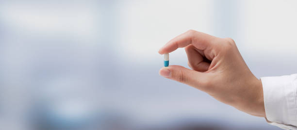 Professional doctor holding a pill Professional doctor holding a pill, medicine and treatment concept antibiotic stock pictures, royalty-free photos & images