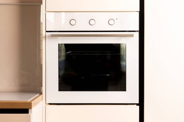 Modern kitchen with built-in oven Modern bright white and beige kitchen with built-in oven closeup oven door stock pictures, royalty-free photos & images