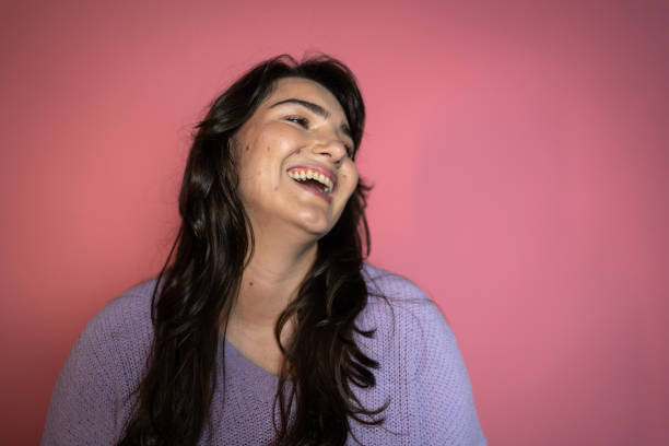 istock Young woman contemplating on a pink background 1423985542