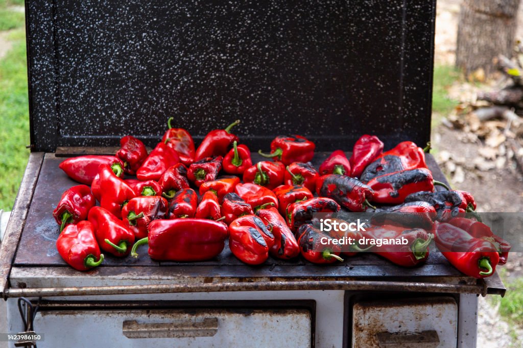 Ajvar homemaking in Serbia Roasting red peppers outdoors on a wood burning stove. Serbian traditional process of making ajvar. Ajvar Stock Photo