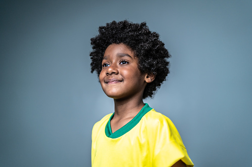 Pride boy looking away wearing brazilian team colors on a gray background
